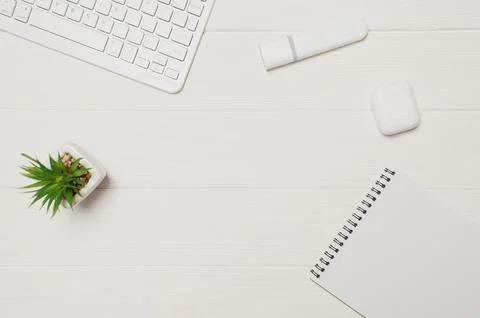 Minimal office desk setup for remote work showing a white keyboard, plant, ma Stock Photos