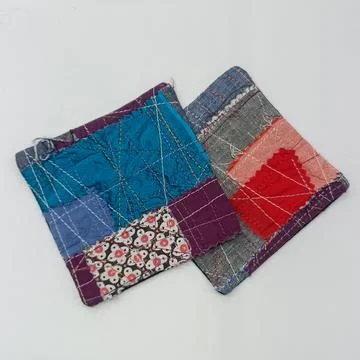 Minimal patchwork fabric coasters on white background. Fotos Stock