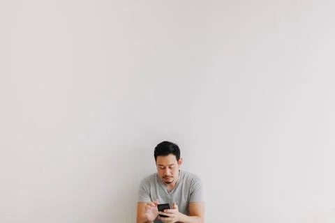 Minimal portrait of man using smartphone at the bottom with empty space. Foto stock