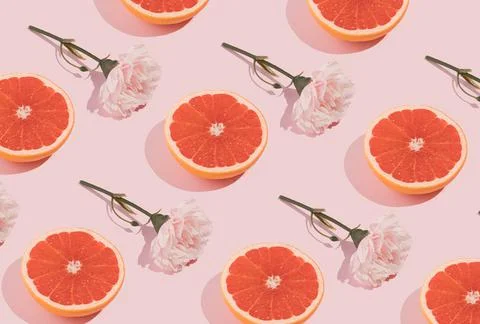 Minimal romatic pattern made with pink flowers and grapefruit on pastel backg Foto stock