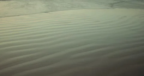 Minimal sand ripple patterns shaped by shallow tidal water on tropical shoreline Stock Footage 336647547