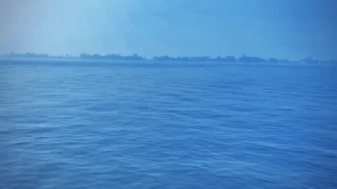 Minimal seascape, deep blue ocean, clear sky, single dark object on horizon Stock-Footage 299812261