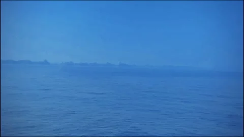 Minimal seascape, deep blue ocean, clear sky, single dark object on horizon Stock-Footage 299812283