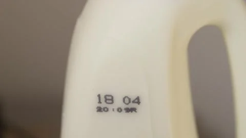 Minimal shot of milk container showing expiry date, representing food safety Stock Footage 332837600