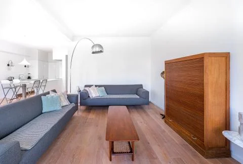 Minimal stylish bright living room with wood floor, big sofas, retro furnitur Stock Photos