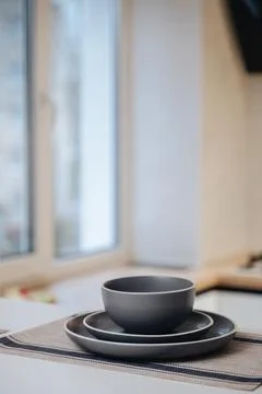 Minimal table setting with gray ceramic plates, modern dining and interior .. Stock Photos