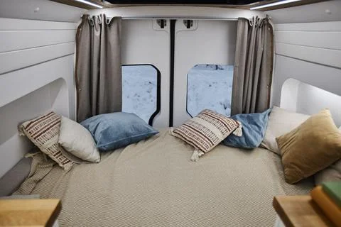 Minimal trailer van interior with bed and cozy throw pillows Stock Photos