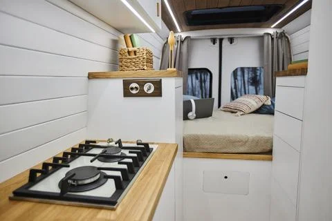 Minimal trailer van interior with focus on small stove in kitchen area Stock Photos