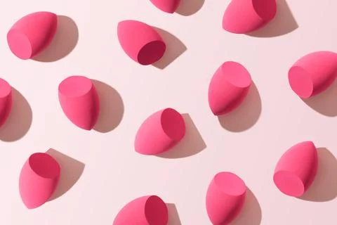 Minimal trend pattern from soft makeup sponges for foundation cream on pink c Stock Photos