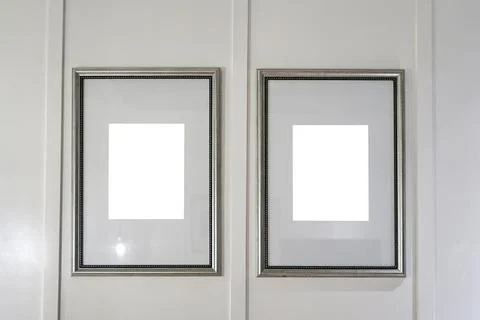 Minimal two empty picture frames with white panel background hanging on wall Foto stock