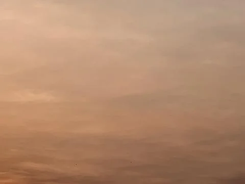 Minimal Warm Peach Sky With Soft Orange Haze and Layered Clouds Stock Photos