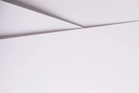 Minimal white ceiling with angular seams. Clean interior surface with soft Stock Photos