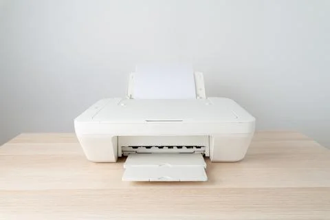 Minimal white printer sits on a light wooden desk in a clean home office sett Stock Photos