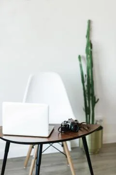 Minimal working place at home with computer, photocamera and cactus Stock Photos