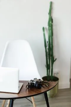 Minimal working place at home with computer, photocamera and cactus Stock Photos