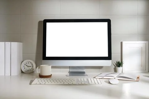 Minimal workspace with white screen computer and office supplies on white t.. Foto stock