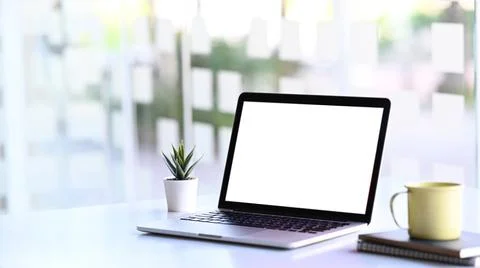 Minimal workstation with mock up laptop computer with white screen, plant, co Stock Photos