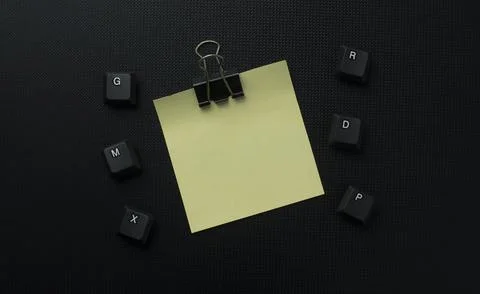 Minimal Yellow Sticky Note With Binder Clip On Dark Keyboard Background Stock Photos