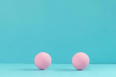 Minimalist abstract composition of two pink spheres on blue background with copy Stock Photos