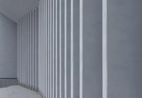 Minimalist architectural corridor with vertical white slats on a gray wall. Stock Photos