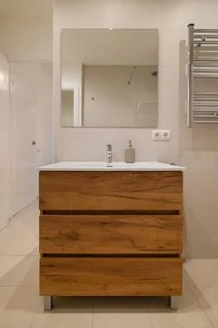 Minimalist bathroom interior with vanity unit, white sink, mirror, toilet and Stock Photos