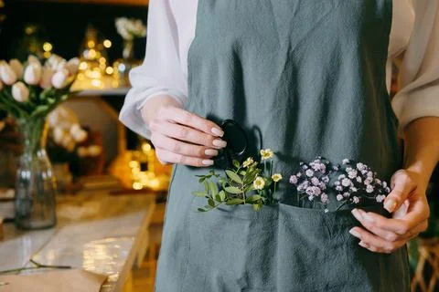Minimalist capture of hands gently displaying small flowers and foliage in an Stock Photos