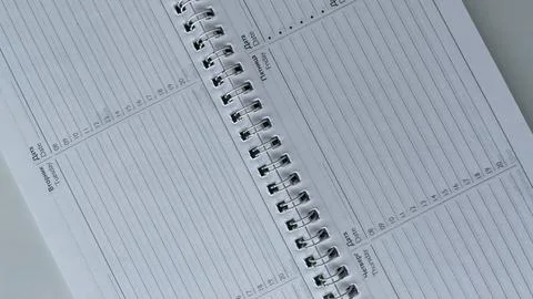 Minimalist close-up of an open spiral-bound weekly planner featuring days o.. Foto stock