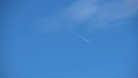 Minimalist composition of a jet stream cutting through a clear azure sky, o.. Stockfoto's