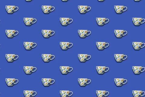 Minimalist composition with repeating Ceramic teacup against a blue backgroun Stock Photos