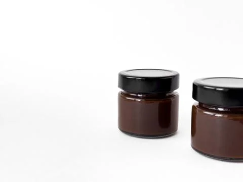 Minimalist composition of two chocolate spread jars on white background Stock-Fotos