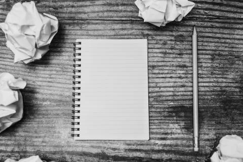 Minimalist desk setting flatlay with opened ruled notepad and pencil surround Stock Photos