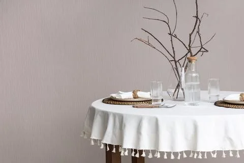 Minimalist dining table with glassware and decorative branches Foto stock