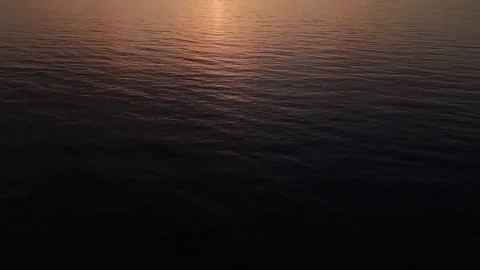 A minimalist drone shot capturing the soft reflections of a sunset on calm ocean Stock Footage 285863784