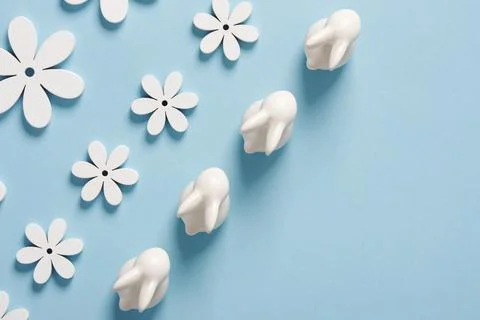 Minimalist Easter composition with white bunnies and flowers on a blue backgr Foto stock