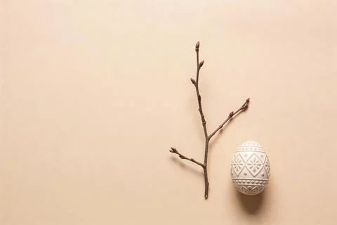 Minimalist Easter egg with a bare branch on a neutral beige background Stock Photos
