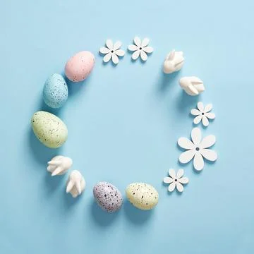 Minimalist Easter frame with white bunnies, colored eggs and wooden flowers o Stock Photos