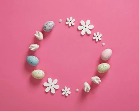 Minimalist Easter frame with white bunnies, colored eggs and wooden flowers o Stock Photos