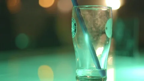 Minimalist Elegance: Shallow Focus Shot of Empty Glass with Straw in Bar Lounge Video stock 78710992