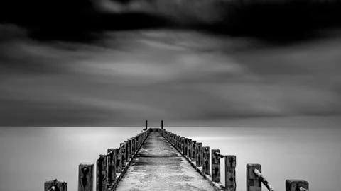 Minimalist Fine art long exposure image in black and white of abandoned jetty. Stock Photos