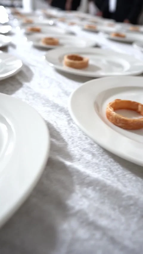 Minimalist fine dining setup with white plates arranged in rows, each holding a Stock Footage 331200976