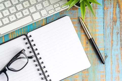 Minimalist flat lay composition of book, fountain pen, plant and glasses Stock Photos