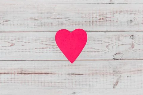Minimalist flat lay composition with red paper heart on white wooden backgrou 库存照片