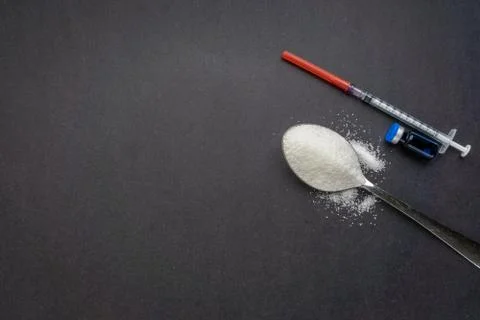 Minimalist flat lay composition sugar, spoon, syringe and vials on the dark b Stock Photos