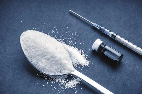 Minimalist flat lay composition sugar, spoon, syringe and vials on the dark b 写真素材
