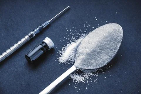 Minimalist flat lay composition sugar, spoon, syringe and vials on the dark b Stock-Fotos