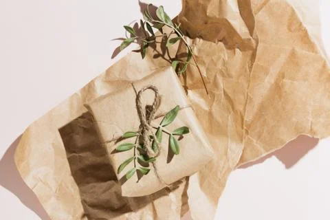 Minimalist flat lay of eco-friendly gift box wrapped in craft paper with pist Stock Photos