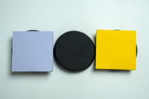 A minimalist flat lay featuring a light blue square note, a black circular .. Stock Photos