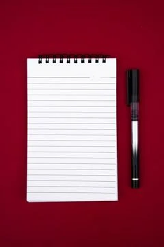 Minimalist Flat Lay of Open Notebook and Pen on Vibrant Red Surface Stock-Fotos