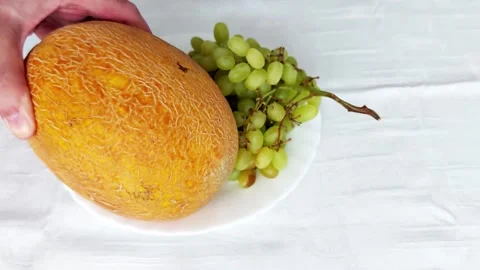 Minimalist Fruit Setup: Orange Melon Green Grapes Close-Up Stock Footage 317073282