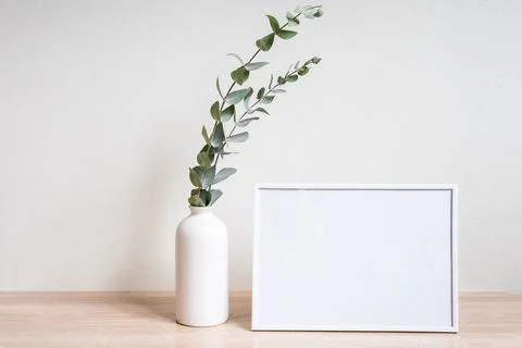 Minimalist home decor with empty frame mock-up on white wall background Stock Photos